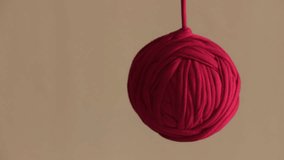 A red thread coiled into a ball shape, hanging down and sliding. - Powered by Shutterstock - Get 15% off with code: PIKWIZARD15