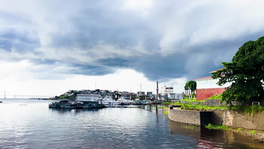 A storm approaches Manaus, Brazil along the Rio Negro (Black River). Vultures flock far in the distance.