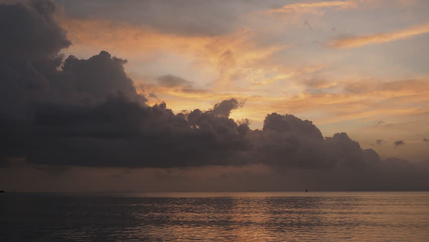 Tropical beach sunset with colorful sky heavy clouds