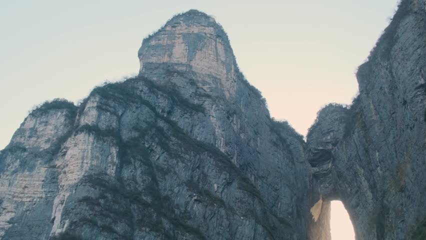 Heaven gate stone arch glowing at sunrise with steep staircase between towering cliffs at sunrise.in Tianmen Mountain National Park, Zhangjiajie, Hunan, China. Tianmen cave with 999 steps