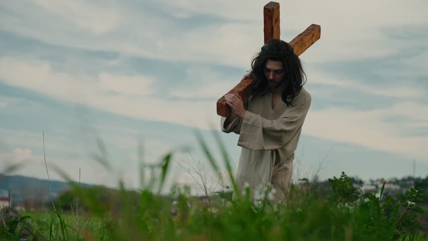 Jesus Christ carrying wooden cross during Easter passion crucifixion journey