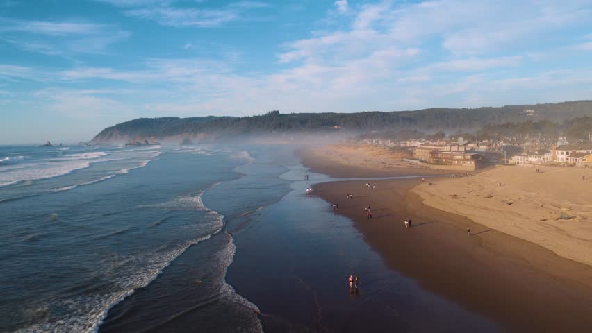 Drone footage showing Cannon Beach cliffs, mountains, and ocean waves. Great for travel, nature, or landscape content.