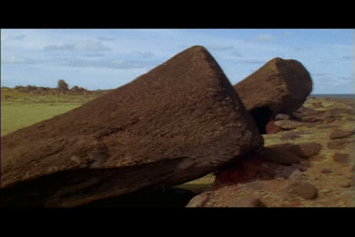 MS fallen moai statue on ground, camera pans left from head to base of statue on Easter Island, Chile.