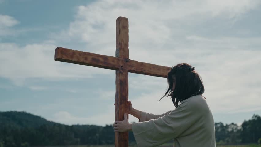 Jesus standing beside wooden cross reflecting in silence during crucifixion journey in slow motion Easter scene