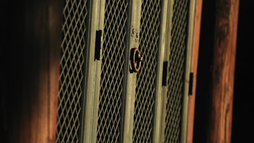 Cinematic close up of traditional Korean temple lattice doors with metal ring handle and geometric patterns in warm sunlight