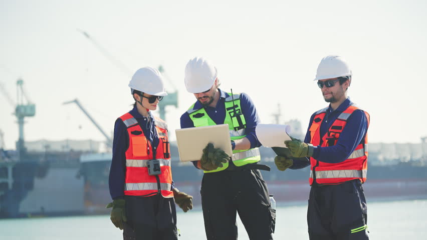 Engineering working at shipyard, Professional logistics monitoring cargo operations at industrial shipyard, transportation, harbor, infrastructure, distribution, freight, commercial shipping.