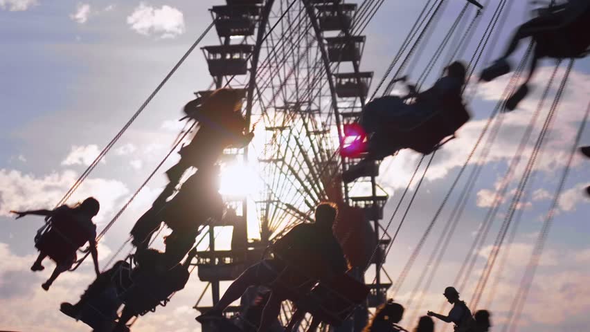Traditional Bavarian folk festival Oktoberfest in Munich with famous rides Wellenflug swing carousel and Willenborgs Riesenrad Ferris wheel. Family fun and German culture at the Theresienwiese