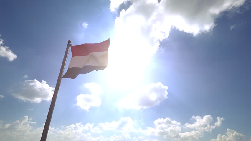 Egypt Flag waving on a Flagpole from a Moving Angle in front of a blue sky with clouds