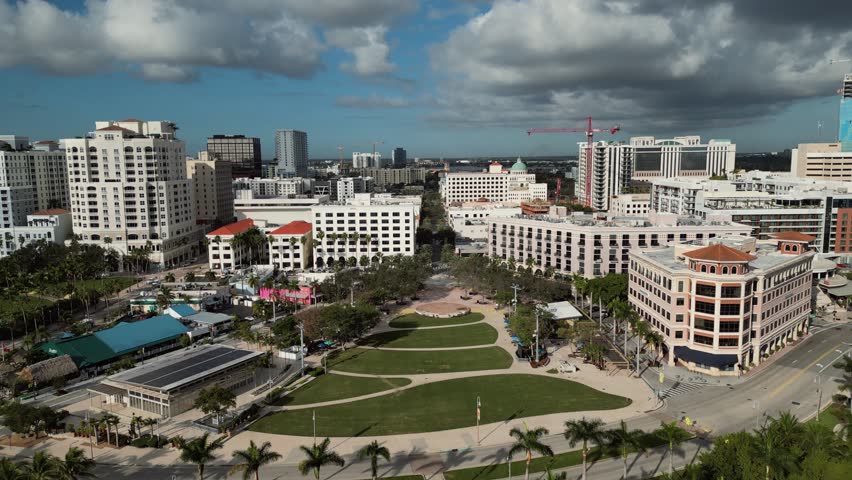 Aerial of West Palm Beach, Florida Cityscape Looking West from Waterfront with Sunlit Green Spaces and Mediterranean Revival Architecture
