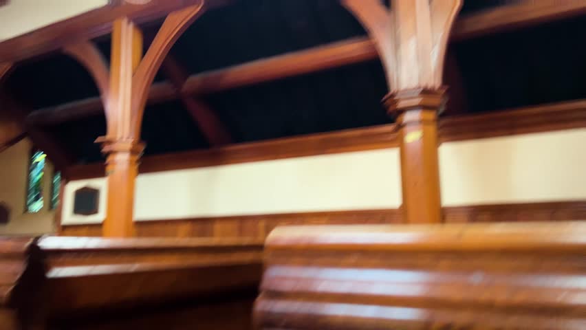 View from the back of the church looking down rows of wooden pews toward the altar