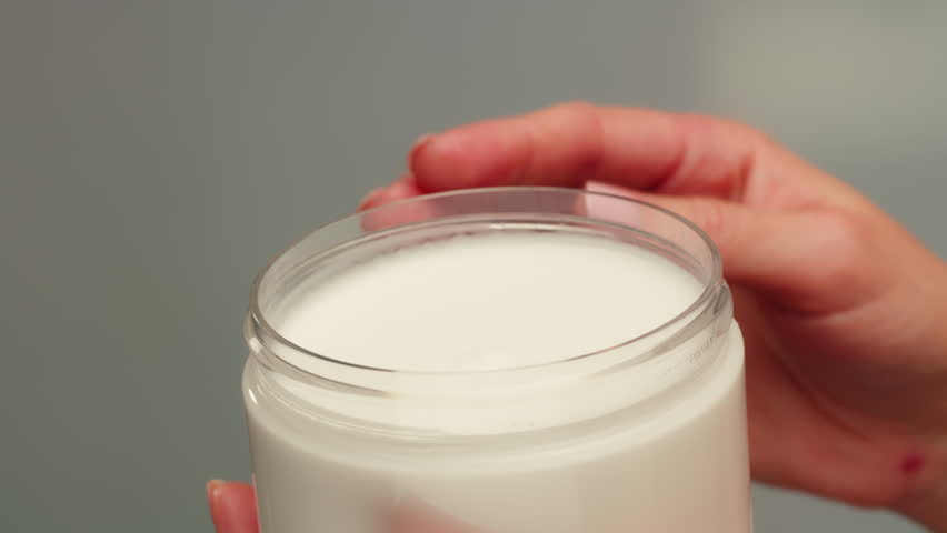 Woman apply cream for hands skin, Close-up of hands with exfoliating cream, demonstrating effective skin care, soft cream foam.