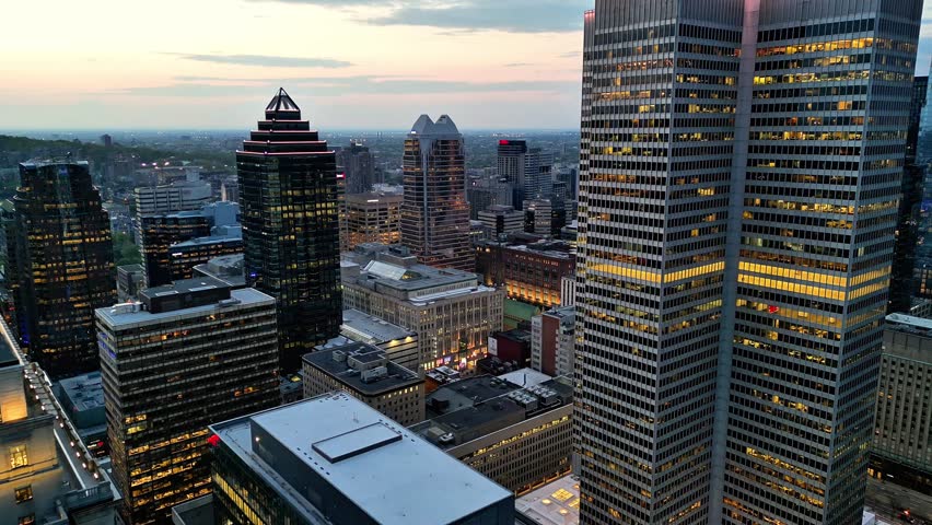 Aerial drone view of downtown Montreal at blue hour featuring the iconic Sun Life Building and surrounding skyscrapers in Quebec, Canada.