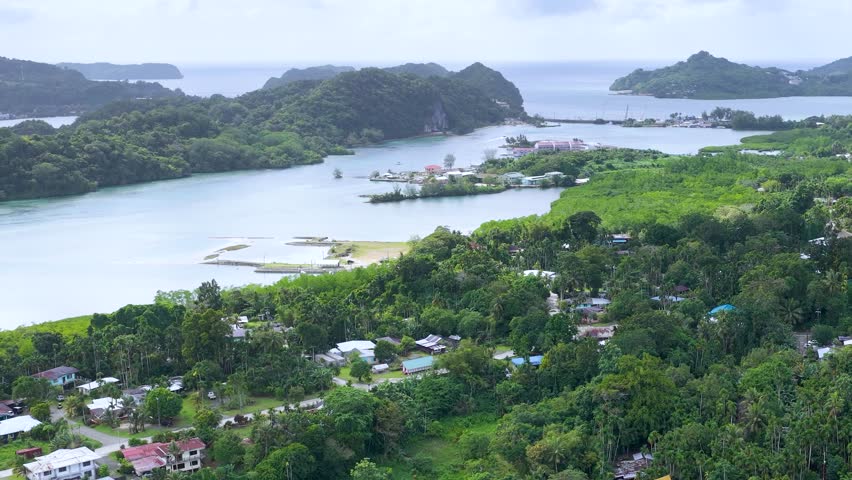 High angle aerial drone shot over lush green tropical islands and turquoise lagoon in Palau