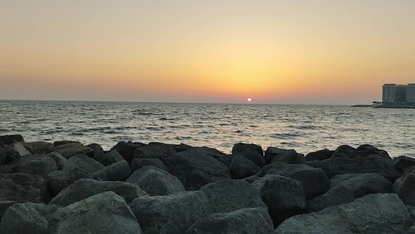 the sun sets over the horizon over the sea. Slow sunset over the sea