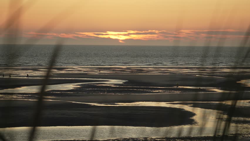 Sun sets over tidal beach pools on the Opal Coast in France.