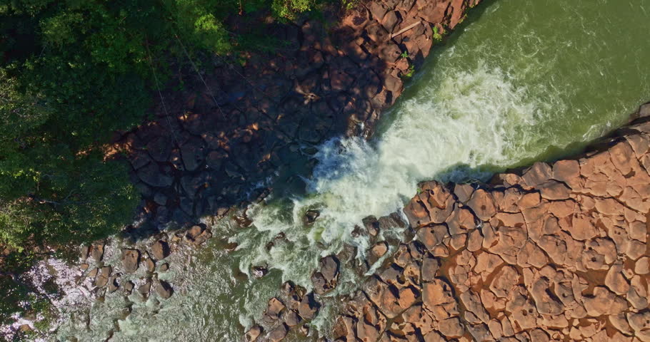 Aerial view of Tad Pha Suam Waterfall near Pakse in Champasak Southern Laos. Water flows over unique column like rock formations surrounded by lush tropical forest, creating a scenic natural