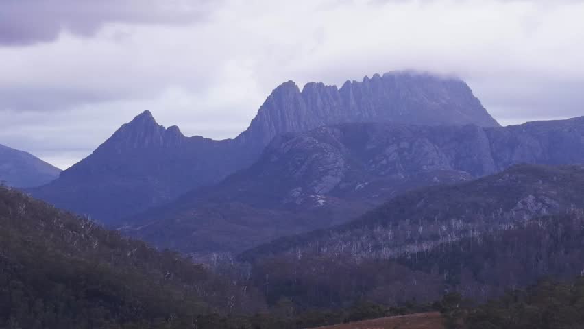 Short aerial up landscape view of Cradle Mount in Tasmania national park at sunset.