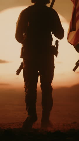 Vertical Screen: Special Forces Soldiers Stride Across a Middle East Desert at Sunset, Weapons Ready, Carrying the American Flag During a Modern Operation For Freedom and Peace. Cinematic Victory