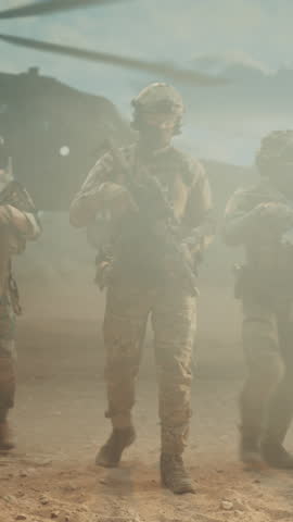 Vertical Screen: Special Forces Soldier Advances Through Middle East Desert Beside Helicopter, Aiming Scoped Rifle, Modern Warfare Combat Operation, Target Coverage, and Tactical Military