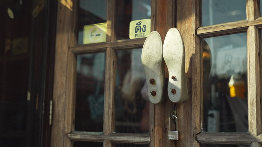 A detailed view of two legs knockers and metal studs on a traditional wooden door with the pull sticker