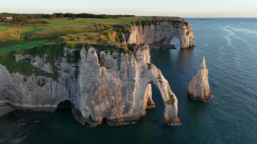 Etretat France dramatic chalk cliffs and sea arches at golden hour