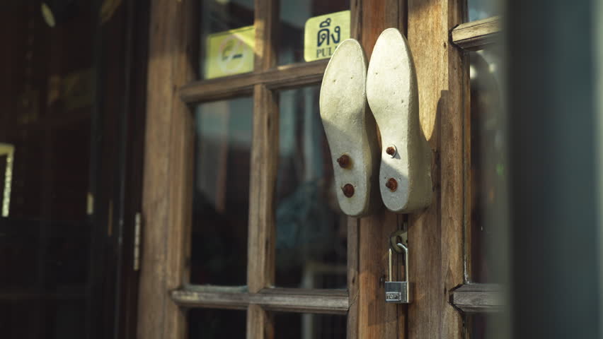 A detailed view of two legs knockers and metal studs on a traditional wooden door with the pull sticker