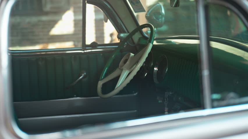 Dashboard of a classic vintage car with car steering wheel in the sunlight