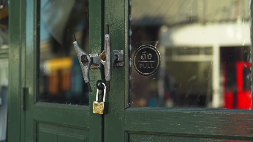 A detailed view of two skateboard chassis knockers and metal studs on a traditional wooden door with the pull sticker