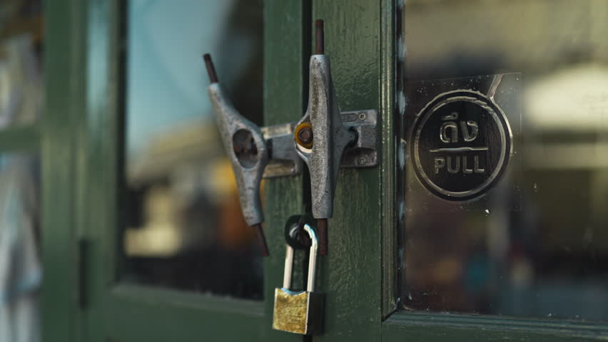 A detailed view of two skateboard chassis knockers and metal studs on a traditional wooden door with the pull sticker