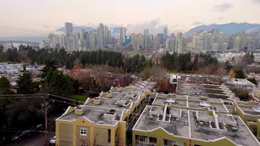Aerial drone footage captures Vancouver cityscape with mountains and water in background