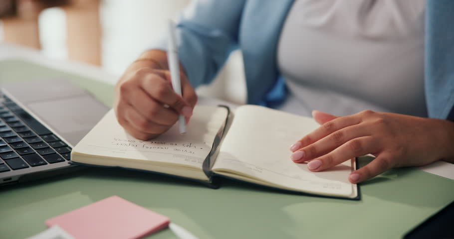 Woman, hands and writing with book for schedule planning, reminder or agenda in office. Female person, employee or taking notes with diary for project ideas, brainstorming or record keeping on desk