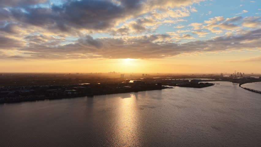 Aerial footage over cityscape at sunset with clouds