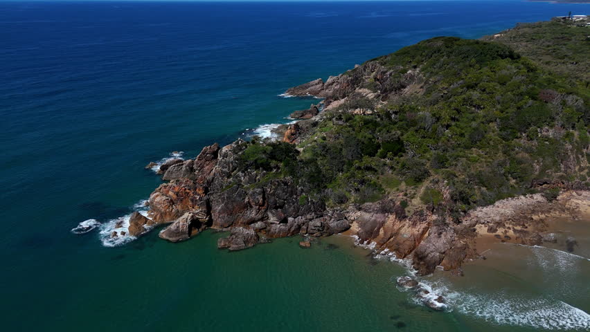 Aerial drone view of coastal cliffs and beach along the scenic Queensland shoreline.