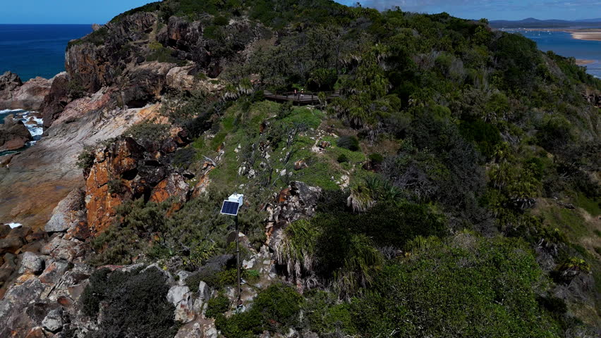 Aerial drone view of rocky headland extending into the blue ocean on the Australian coastline.