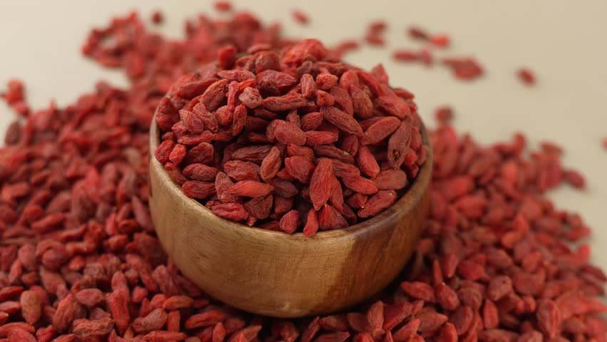 Dried Goji berries or Wolfberry on a wooden bowl panning shot.