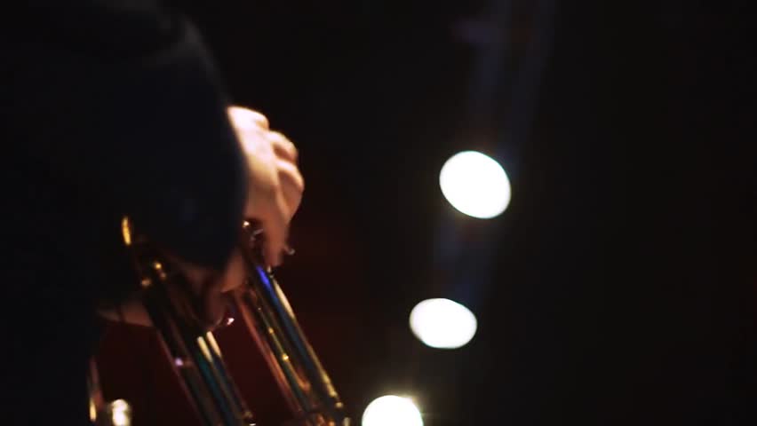 Two men playing trumpets on stage, performing live music in a concert setting, capturing musical performance, energy, and entertainment.
