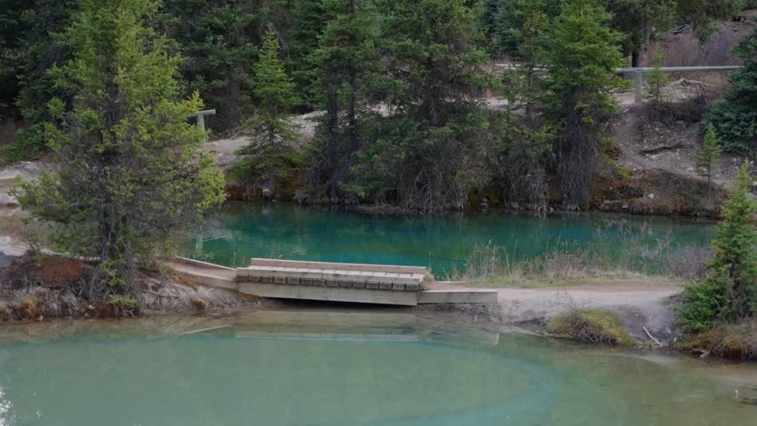 Woman walking on bridge over Ink Pots in Jasper National Park, Canada