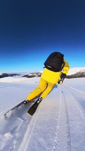 Skier Enjoying a Freeride Descent on a Sunny Winter Day in the Snowy Mountains