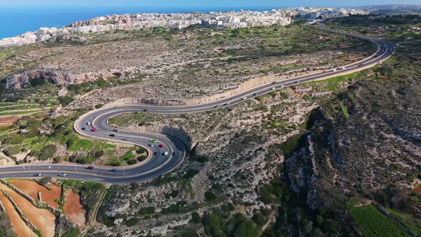 Aerial view of a winding serpentine road cutting through Mellieha