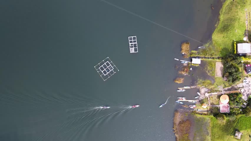The scene captures vibrant boats navigating Cumbal Lagoon, surrounded by greenery and fish nets under clear skies.
