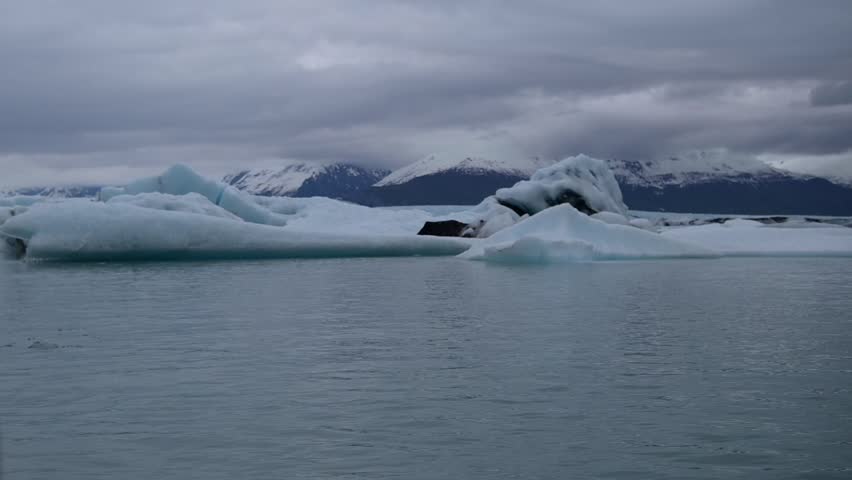 Cinematic handheld POV footage of a small boat navigating through ice chunks and icebergs on Matanuska Glacier in Alaska.  Ideal for dramatic, adventure, relaxing, travel, outdoor, and glacier-themed projects. 