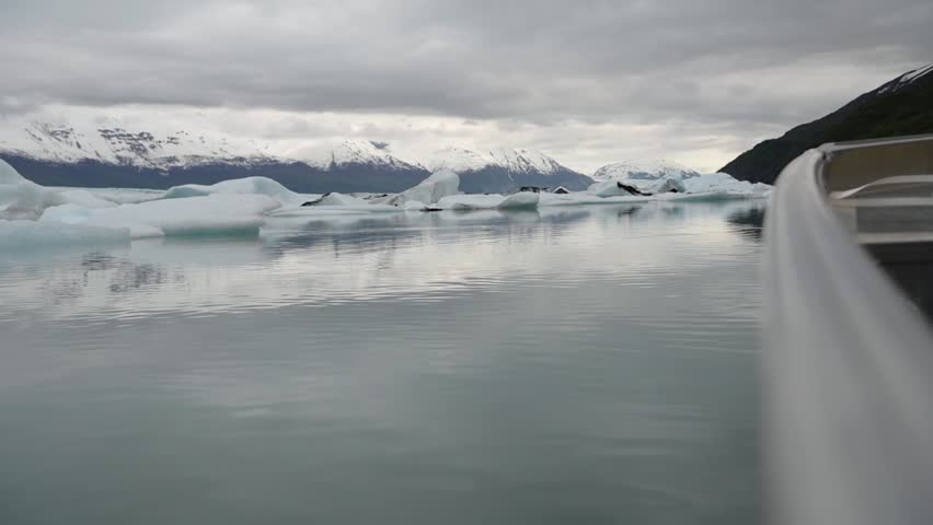 Cinematic handheld POV footage of a small boat navigating through ice chunks and icebergs on Matanuska Glacier in Alaska.  Ideal for dramatic, adventure, relaxing, travel, outdoor, and glacier-themed projects. 