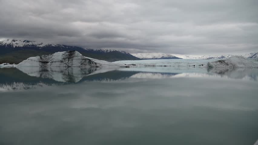 Cinematic handheld POV footage of a small boat navigating through ice chunks and icebergs on Matanuska Glacier in Alaska.  Ideal for dramatic, adventure, relaxing, travel, outdoor, and glacier-themed projects. 