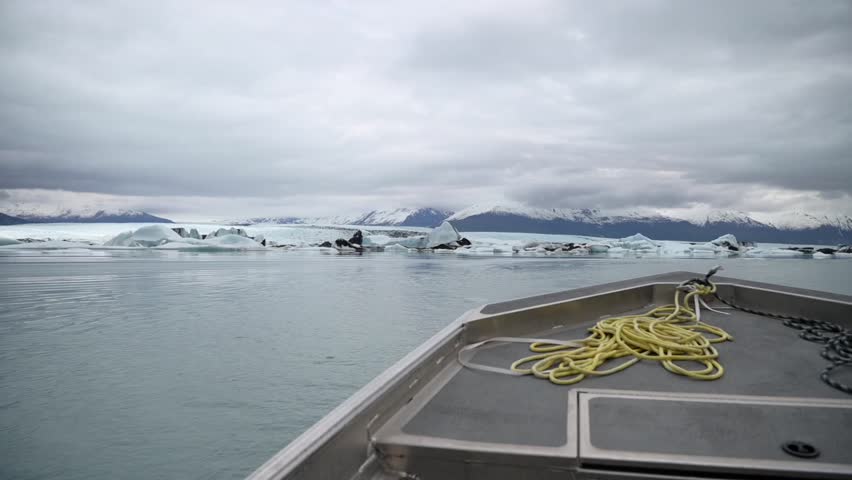 Slow motion cinematic handheld POV footage of a small boat navigating through ice chunks and icebergs on Matanuska Glacier in Alaska.  Ideal for dramatic, adventure, relaxing, travel, outdoor, and glacier-themed projects. 