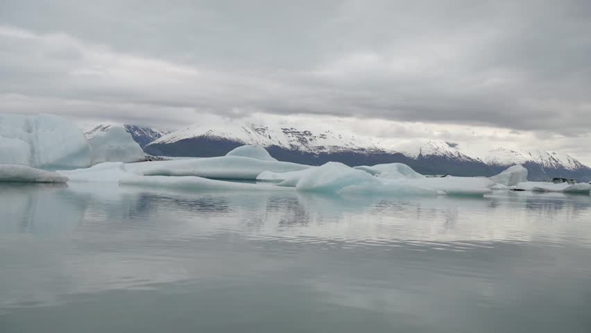 Slow motion cinematic handheld POV footage of a small boat navigating through ice chunks and icebergs on Matanuska Glacier in Alaska.  Ideal for dramatic, adventure, relaxing, travel, outdoor, and glacier-themed projects. 