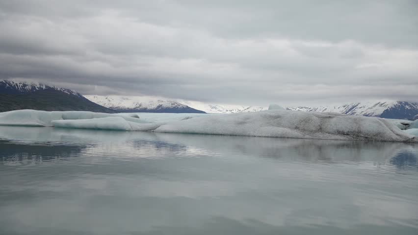 Slow motion cinematic handheld POV footage of a small boat navigating through ice chunks and icebergs on Matanuska Glacier in Alaska.  Ideal for dramatic, adventure, relaxing, travel, outdoor, and glacier-themed projects. 