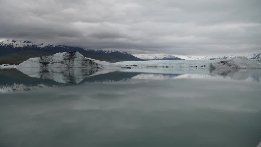 Slow motion cinematic handheld POV footage of a small boat navigating through ice chunks and icebergs on Matanuska Glacier in Alaska.  Ideal for dramatic, adventure, relaxing, travel, outdoor, and glacier-themed projects. 
