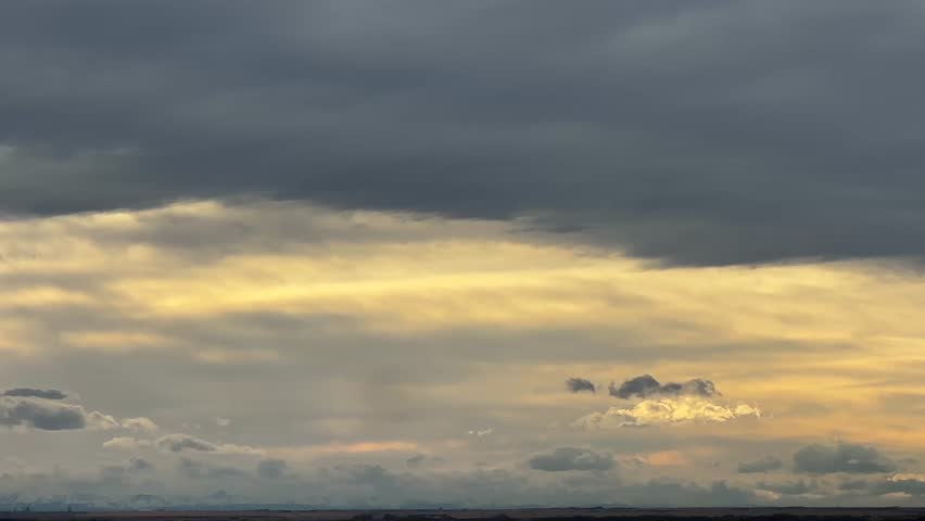 Open agricultural field with textured soil and prairie horizon under cloudy sky