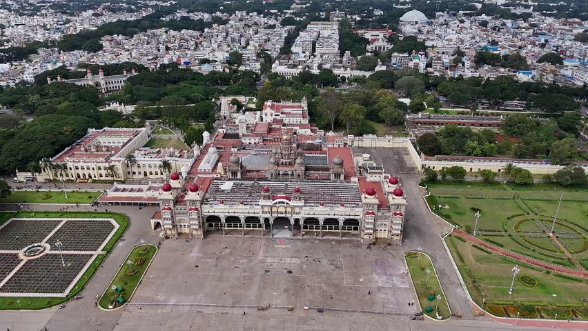 Cinematic drone view of Mysore Palace or Amba Vilas a historic royal residence rising majestically amidst the vibrant Mysore cityscape in Karnataka, India, showcasing grand heritage architecture