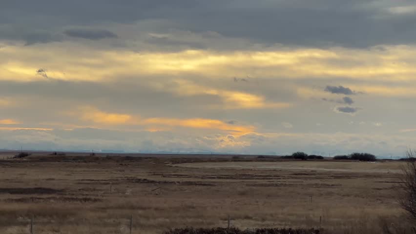 Dramatic storm clouds rolling over wide prairie landscape with open horizon